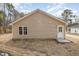 Rear exterior of home with beige siding, white trim, a window, and an entry door at 303 E Pope Ave, Kenly, NC 27542