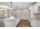 Well-lit kitchen featuring a granite island, white cabinetry, modern fixtures, and beautiful hardwood floors at 303 E Pope Ave, Kenly, NC 27542