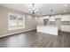 Bright kitchen with white cabinets, granite countertops, stainless steel appliances, and hardwood floors at 303 E Pope Ave, Kenly, NC 27542