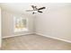A bright bedroom with neutral carpeting, a ceiling fan, and a large window offering natural light and outside views at 307 E Pope Ave, Kenly, NC 27542