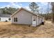 Rear exterior elevation featuring neutral siding, white door and window trim, and simple landscape at 307 E Pope Ave, Kenly, NC 27542