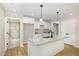 Well-lit kitchen with island, white cabinetry, granite countertops, and stainless steel sink at 307 E Pope Ave, Kenly, NC 27542
