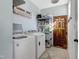 Well-lit laundry room features a washer, dryer, storage shelves, and a door at 309 14Th St, Butner, NC 27509