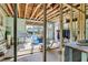 Unfinished room with exposed wood beams, a large window, and supplies at 309 14Th St, Butner, NC 27509