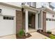 Welcoming townhome entrance with brick columns, covered porch, and access to the garage at 309 Millennium Dr, Pittsboro, NC 27312