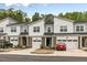 Modern townhome complex featuring brick and siding exteriors, garages, and manicured lawns at 309 Millennium Dr, Pittsboro, NC 27312