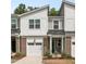 Charming townhome exterior featuring a brick facade, garage, and well-maintained landscaping at 309 Millennium Dr, Pittsboro, NC 27312