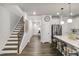 Hallway flows into open kitchen with an island, stainless steel appliances, and counter seating at 309 Millennium Dr, Pittsboro, NC 27312