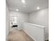 Upstairs hallway with neutral carpet leading to bedrooms at 309 Millennium Dr, Pittsboro, NC 27312