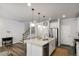 Open-concept kitchen featuring a large island, white cabinetry, and stainless steel appliances at 309 Millennium Dr, Pittsboro, NC 27312