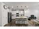 Open-concept kitchen with stainless steel appliances, white cabinetry, and island seating at 309 Millennium Dr, Pittsboro, NC 27312