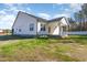 Exterior view showcasing the back of the house, featuring white siding, a dark roof, and a covered porch at 32 Bonnybrook Ct, Selma, NC 27576