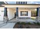 Welcoming front porch with stone accents, black support beams, and tasteful lighting at 32 Bonnybrook Ct, Selma, NC 27576