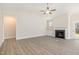 Open living area featuring gray floors, a fireplace, and ample natural light from the windows at 32 Bonnybrook Ct, Selma, NC 27576