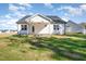 Rear exterior of the home featuring a covered porch, white siding, dark roof, and a well-maintained lawn at 32 Bonnybrook Ct, Selma, NC 27576