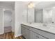 A bathroom with double vanity, gray cabinetry, a large mirror, and an entrance to the closet at 33 W Emily Gardens Dr, Selma, NC 27576