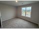 Empty carpeted bedroom space featuring a large window overlooking the community at 33 W Emily Gardens Dr, Selma, NC 27576