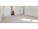 A large, bright bedroom with gray carpet, neutral walls, and an open door to the en-suite bath at 33 W Emily Gardens Dr, Selma, NC 27576