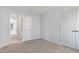A bright bedroom with gray carpet and neutral walls, with an open doorway and closet access at 33 W Emily Gardens Dr, Selma, NC 27576