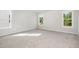 A spacious bedroom with soft gray carpet and three large windows providing plenty of natural light at 33 W Emily Gardens Dr, Selma, NC 27576