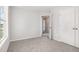 A sunny bedroom with gray carpet, bright walls, a large window, and closet access at 33 W Emily Gardens Dr, Selma, NC 27576