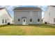 Back exterior showing grey siding, a rear door, and a lush, green lawn at 33 W Emily Gardens Dr, Selma, NC 27576