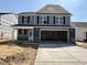 New two-story home with a two-car garage and stone-accented facade, awaiting landscaping at 33 W Emily Gardens Dr, Selma, NC 27576