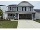 Two-story home featuring gray siding, black shutters, a spacious garage, and a well-manicured lawn at 33 W Emily Gardens Dr, Selma, NC 27576