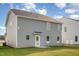 Back exterior featuring grey siding, rear door, and well-maintained lawn at 33 W Emily Gardens Dr, Selma, NC 27576