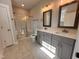Well-lit bathroom featuring a double vanity, gray cabinets, quartz countertops, and a glass-enclosed shower at 39 N Rowsham Pl, Smithfield, NC 27577