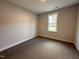 Carpeted bedroom with natural light streaming through a window with neutral colored walls at 39 N Rowsham Pl, Smithfield, NC 27577