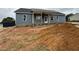 New construction shows the house's exterior and porch with fan and white trim, and a large dirt mound at 40 Bailey-Boykin Rd, Selma, NC 27576