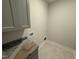 The laundry room features grey cabinetry, a granite countertop, and tile flooring at 40 Bailey-Boykin Rd, Selma, NC 27576
