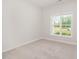 A bright bedroom features neutral walls and large window showing green outdoor space at 40 Tuskeegee Dr, Smithfield, NC 27577