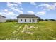Rear exterior view of a white single-Gathering home with a dark roof and a spacious lawn at 40 Tuskeegee Dr, Smithfield, NC 27577