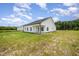 Angled view of the white exterior of the home, showing the backyard and covered porch at 40 Tuskeegee Dr, Smithfield, NC 27577