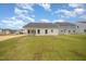 A spacious backyard with a newly installed lawn, showcasing the home's rear exterior and patio at 41 W Emily Gardens Dr, Selma, NC 27576