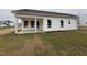 Image of backyard with a covered porch and new sod being installed on a cloudy day at 41 W Emily Gardens Dr, Selma, NC 27576