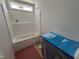 Bathroom with a white shower-tub, grey vanity cabinets, and a window for natural light at 41 W Emily Gardens Dr, Selma, NC 27576