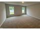 Spacious bedroom with plush carpet, natural lighting from the two windows, and neutral wall color at 41 W Emily Gardens Dr, Selma, NC 27576