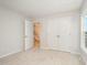 Bright bedroom with neutral carpeting, a closet, and views of the staircase through the doorway at 41 W Emily Gardens Dr, Selma, NC 27576