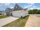 Exterior view of a two-car garage with vinyl siding and a paved driveway and landscaping at 41 W Emily Gardens Dr, Selma, NC 27576