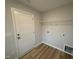 Laundry room with white door, shelving and hardwood floors, and washer/dryer hookups at 41 W Emily Gardens Dr, Selma, NC 27576
