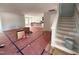 Spacious, unfinished living room area featuring light-grey walls, an open staircase, and access to the kitchen at 41 W Emily Gardens Dr, Selma, NC 27576