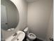 Modern half bathroom features a round mirror and sleek fixtures at 43 Chloe Ct, Selma, NC 27576