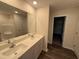 Bathroom featuring double sinks with quartz countertops, a large mirror, and vinyl flooring at 43 Chloe Ct, Selma, NC 27576