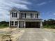 Two story home featuring black shutters, light gray siding, and a large two car garage at 43 Chloe Ct, Selma, NC 27577