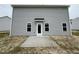 Exterior of a house with gray siding, a concrete patio, and a white door at 43 Chloe Ct, Selma, NC 27577