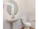 Cozy half bathroom features pedestal sink, rounded mirror, and neutral paint at 46 Lupin Dr, Smithfield, NC 27577