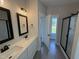 Bathroom showcasing double sinks, elegant lighting fixtures, modern framed mirrors, and a glass door shower at 47 Royal Ave, Selma, NC 27576